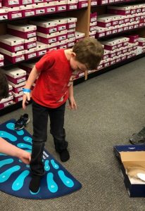 Boy shoe shopping at Canyon County Branch's first Operation School Bell event.