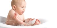 child in bath splashing water