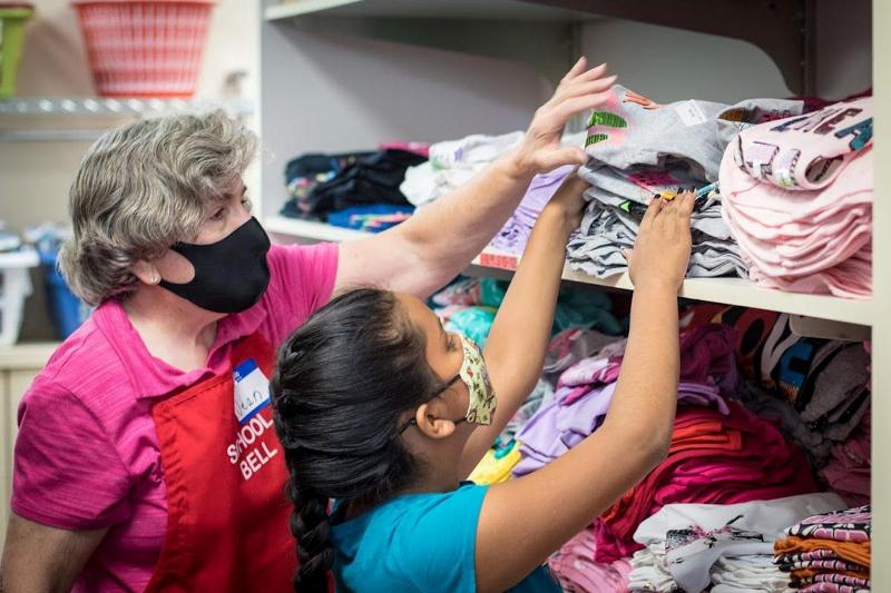 614383ca867ba.image 800x533 An Assistance League of Boise volunteer helps a child find the right shirt at Operaiton School Bell