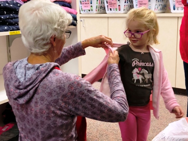 Girl Trying on Sweatshirt 640x480 Member helping child try on new sweatshirt