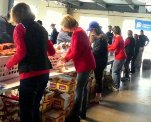 An assembly line of workers for the Weekend Food for Kids event