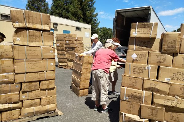 Volunteers unloading boxes of uniforms for OSB