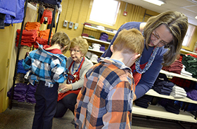 Wendy Brown, Fort Bliss Bugle Editor Maryanne Benson, right, and Flo McCloskey, back left, Operation School Bell volunteers, help a pair of Bliss Elementary School students find clothes at the organization’s headquarters at 2728 E. Yandell Drive, El Paso, Jan. 26.