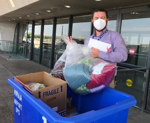 Northern Virginia - Assistance League Delivered items for Afghan Refugees Man places bags in blue crate