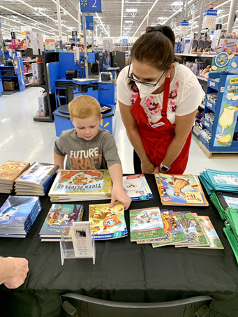 Sierra Foothills - Assistance League Helps Caldor Fire Victims A person and a child looking at a book on a table